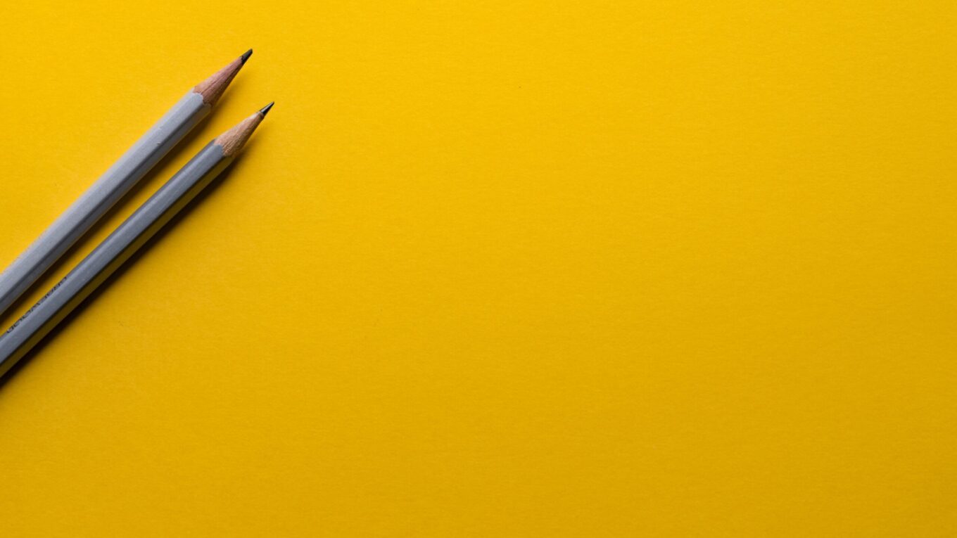 Two pencils on a yellow piece of card